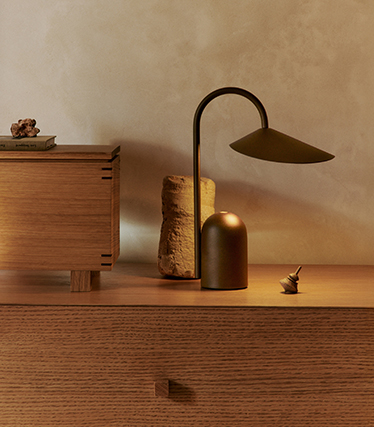 Elegant table lamp with sculptural design on a wooden sideboard in soft ambient light
